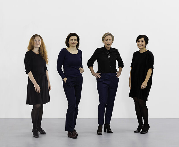 
            
                vier stehende Frauen vor einer weißen Wand: das Team der Direktion im mumok
            
        