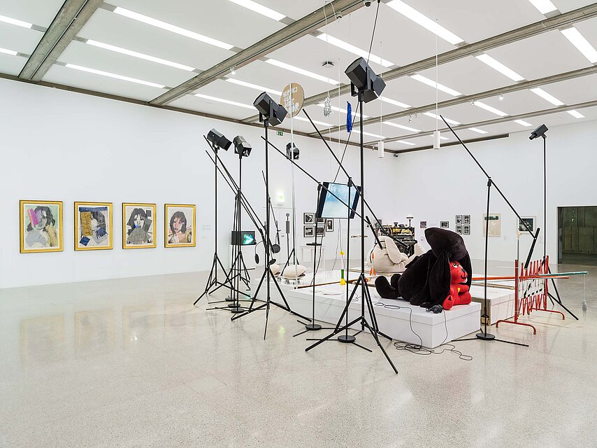 Artistic installation with spotlights and soft toys in a bright exhibition space