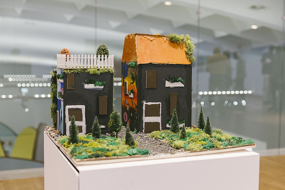Modell von zwei schwarzen Häusern mit Begrünung
