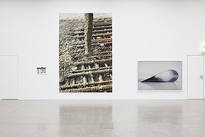 Ausstellungsraum mit Fotografien in unterschiedlichen Formaten an der weißen Wand