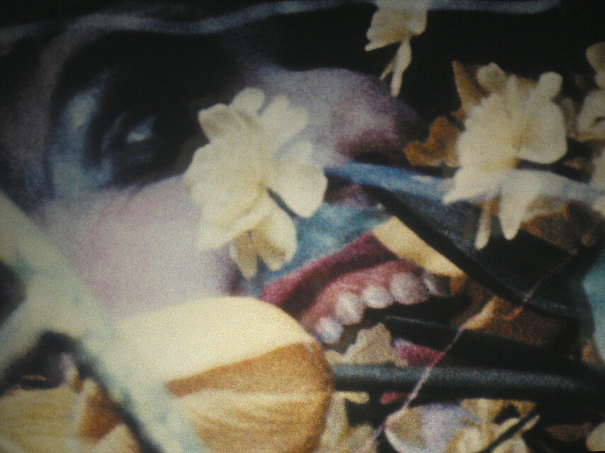 Jack Smith, Filmstill aus / from: Yellow Sequence, 1963: Ein Gesicht mit offenem Mund scheint in Blumen zu beißen