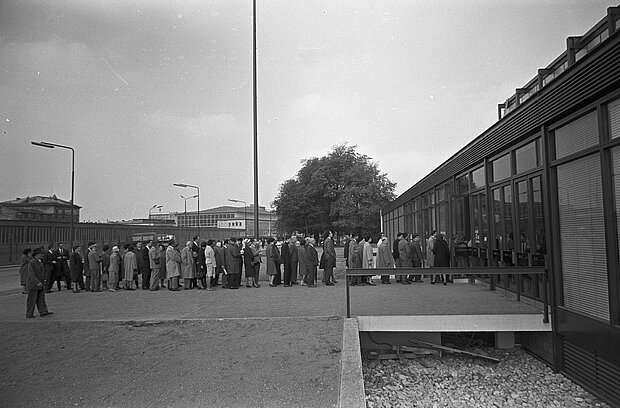 
            
                Black and white photo of the opening of the Museum of the 20th Century in 1962, on the right is a building in front of which there is a long line of people
            
        